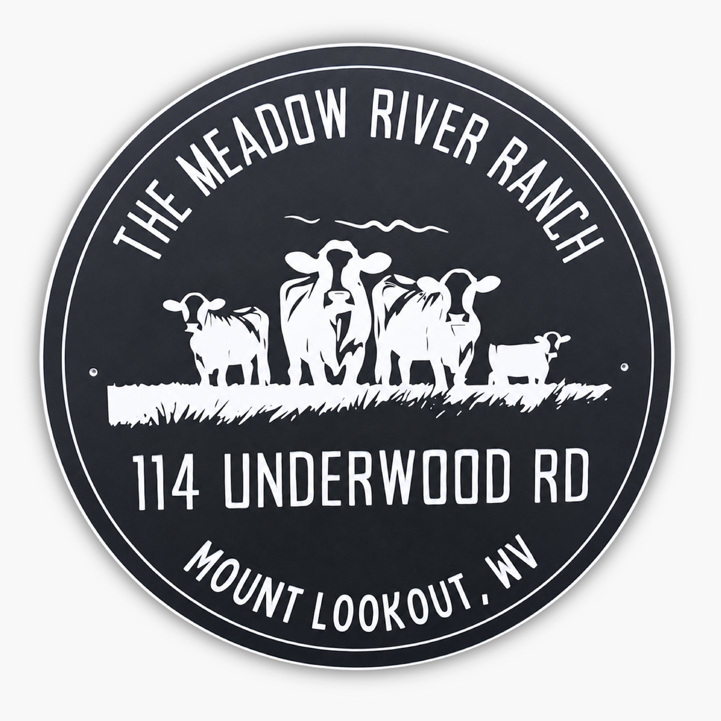 A round sign with The Meadow River Ranch at the top, 114 Underwood Rd, and Mount Lookout, WV at the bottom. In the center, there are silhouettes of three cows and a small calf standing on grass. The sign has a black background with white text and images.