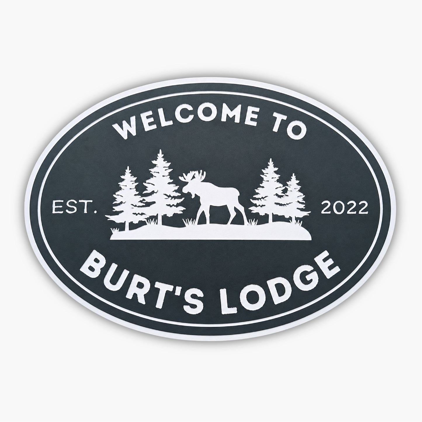 The Personalized Oval Custom Beach House Sign features Welcome to Burts Lodge, showcasing a moose and pine trees silhouette. Its dark background with white lettering reads Est. 2022, echoing the elegance of classic coastal decor.