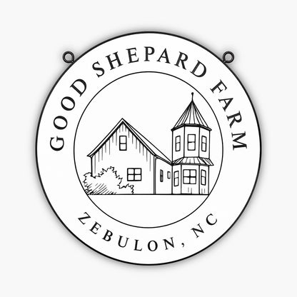 A Custom Carved Ranch & Farm Sign made of engraved PVC displays GOOD SHEPARD FARM and ZEBULON, NC, with a farmhouse and tower line drawing in the center, shown mounted on beige siding.