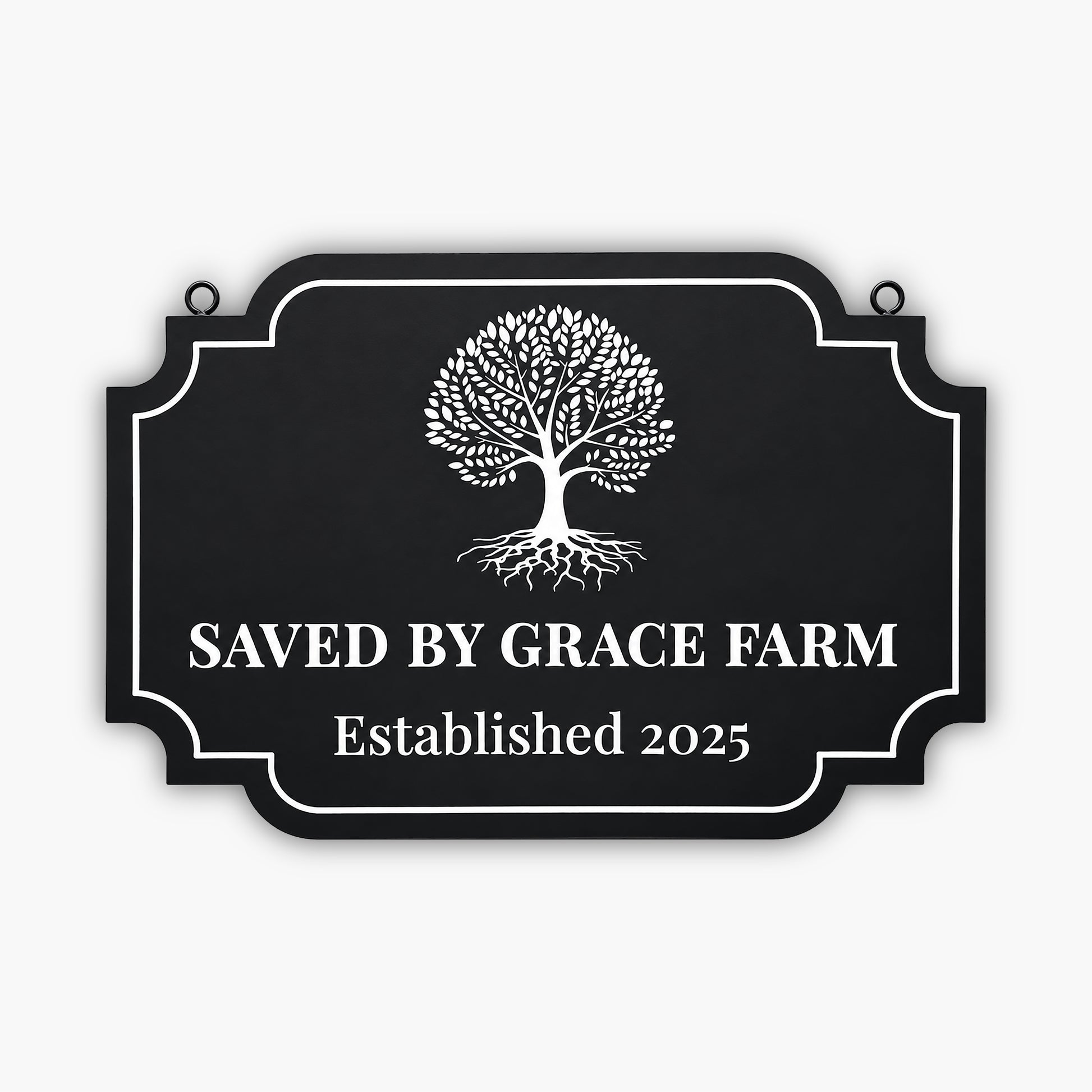 A black sign with a white tree graphic and the text SAVED BY GRACE FARM Established 2025 written in large, bold letters. The sign has a decorative border and is mounted on a wooden wall.