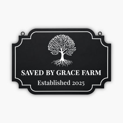 A black sign with a white tree graphic and the text SAVED BY GRACE FARM Established 2025 written in large, bold letters. The sign has a decorative border and is mounted on a wooden wall.