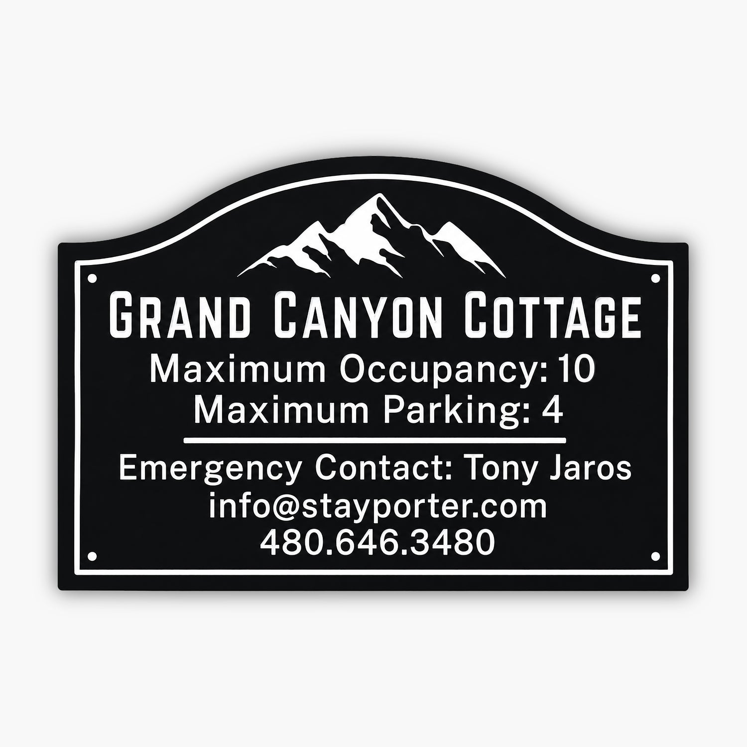 A sign for Grand Canyon Cottage with a mountain graphic. It states: Maximum Occupancy: 10, Maximum Parking: 4, Emergency Contact: Tony Jaros, info@stayporter.com, 480.646.3480.