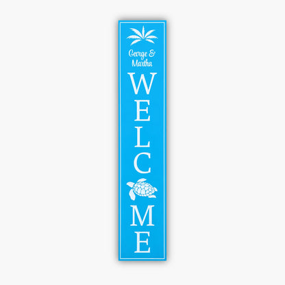 A personalized blue vertical welcome sign, George & Martha WELCOME, features palm trees and a turtle on durable PVC with horizontal beige siding, perfect for a coastal decor.