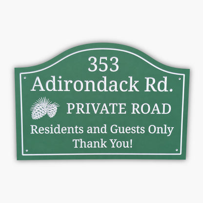A green sign reads: 353 Adirondack Rd. PRIVATE ROAD Residents and Guests Only Thank You! with a pinecone graphic on the left. The background is tan siding.