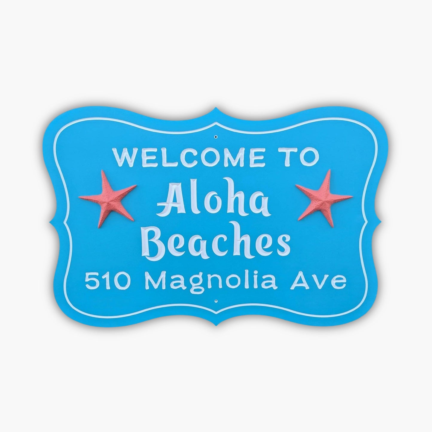 A personalized custom carved 3D PVC sign in blue with white letters says Welcome to Aloha Beaches, 510 Magnolia Ave, and includes two red starfish flanking Aloha Beaches.