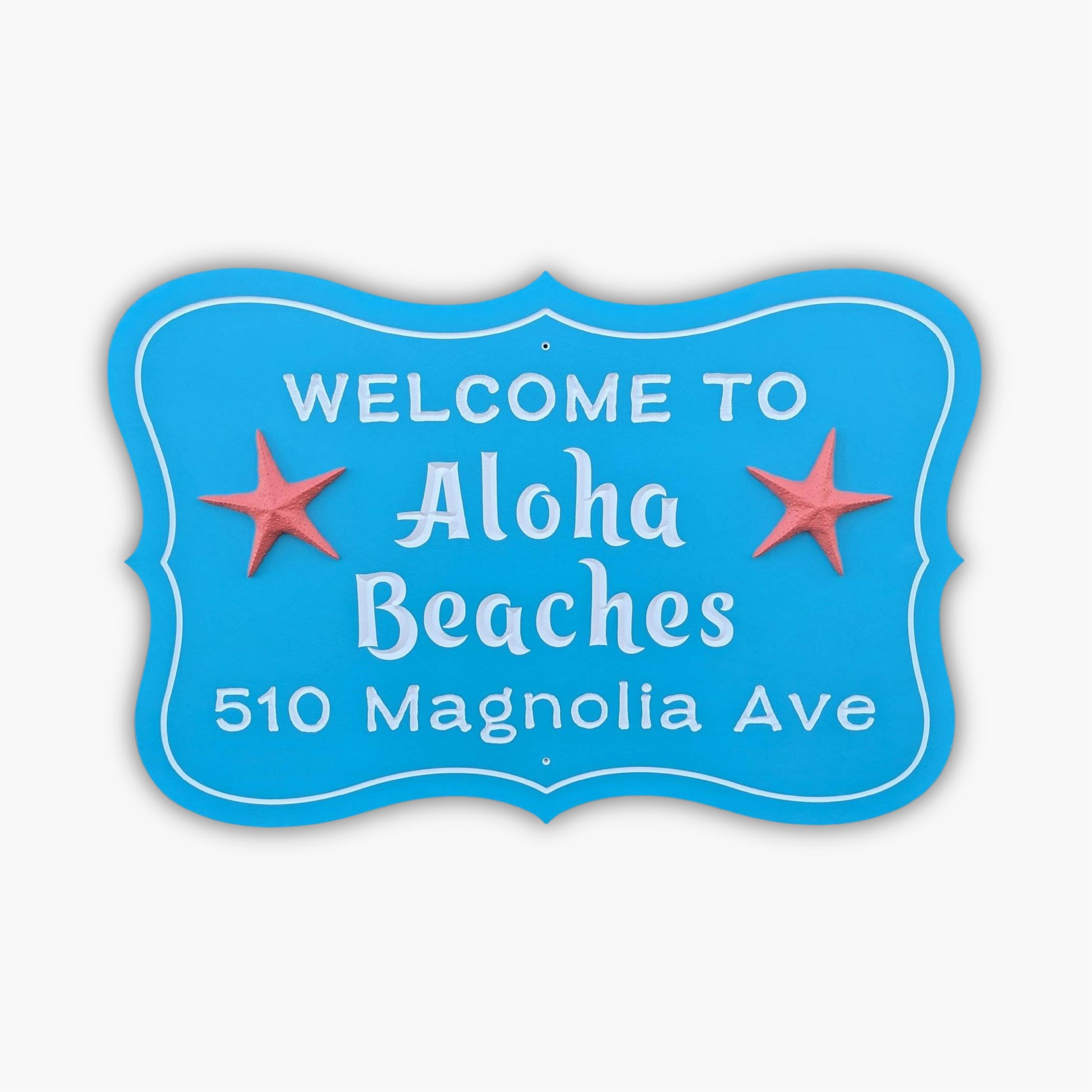 A personalized custom carved 3D PVC sign in blue with white letters says Welcome to Aloha Beaches, 510 Magnolia Ave, and includes two red starfish flanking Aloha Beaches.