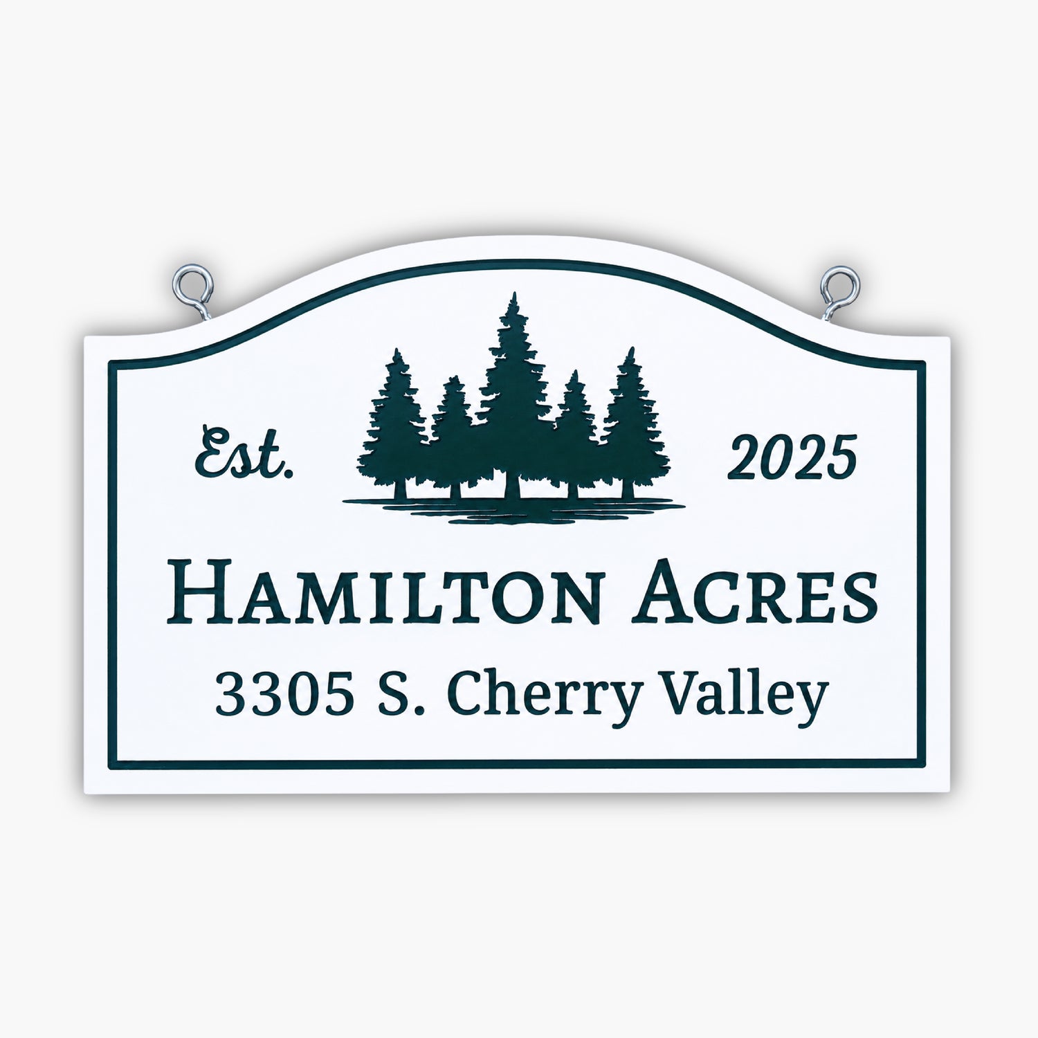 A white sign with green text and tree silhouettes reads: Est. 2025 HAMILTON ACRES 3305 S. Cherry Valley. The sign is displayed in front of a beige, paneled wall.