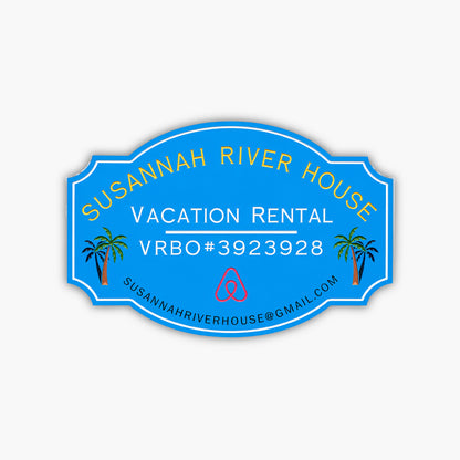 A custom home rental sign for Susannah River House features vibrant yellow and white text on a blue oval background with Vacation Rental VRBO#3923928, an Airbnb logo, palm tree illustrations, and the email address susannahriverhouse@gmail.com.