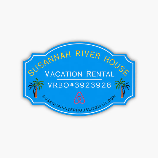 A custom home rental sign for Susannah River House features vibrant yellow and white text on a blue oval background with Vacation Rental VRBO#3923928, an Airbnb logo, palm tree illustrations, and the email address susannahriverhouse@gmail.com.