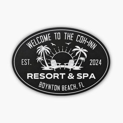 Oval sign reading Welcome to the Coh-Inn, Resort & Spa, Boynton Beach, FL, with established date 2024. The scene resembles an art gallery with a sunset backdrop featuring palm trees, birds, and two chairs against a wooden wall.