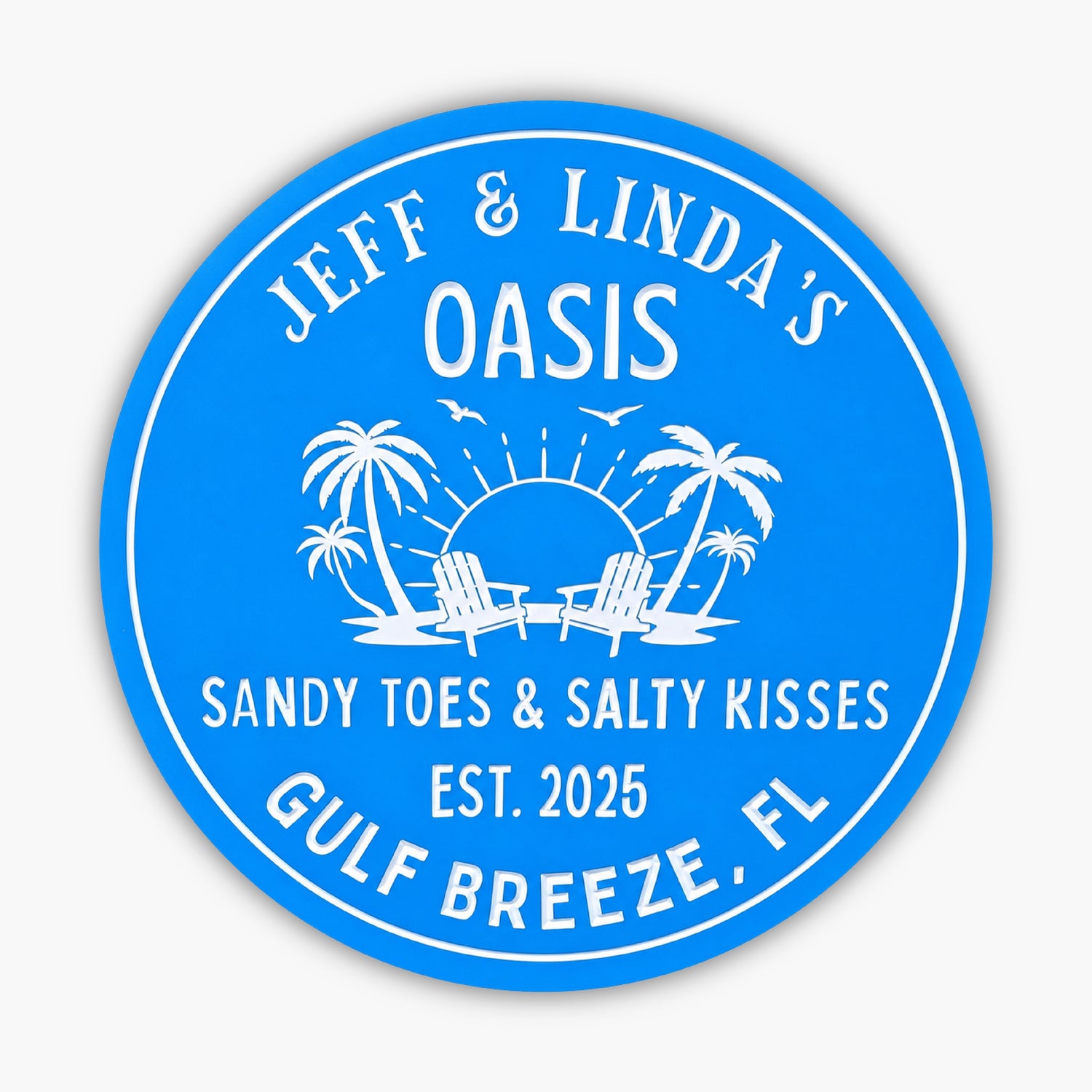A round blue sign reads: Jeff & Lindas Oasis. Sandy Toes & Salty Kisses. Est. 2025. Gulf Breeze, FL, with a design of palm trees, Adirondack chairs, sun, and birds.