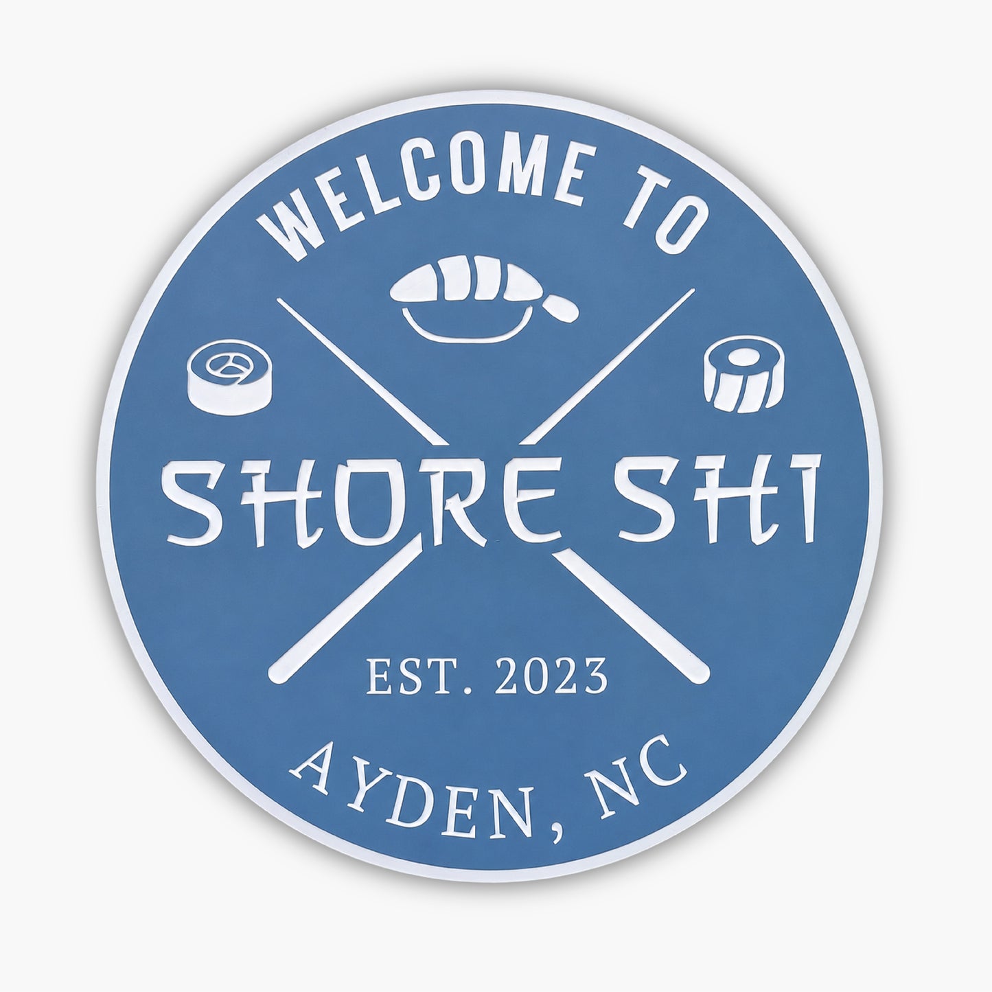 A round blue Personalized Custom Round Beach House Sign features the white text Welcome to Shore Shi, embellished with sushi rolls, crossed chopsticks, Est. 2023, and Ayden, NC.
