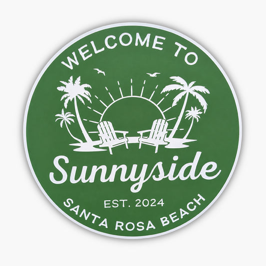 A personalized Beach House sign in green with white text and graphics reads Welcome to Sunnyside, Est. 2024, Santa Rosa Beach, featuring two chairs, palm trees, a sun with rays, and birds.