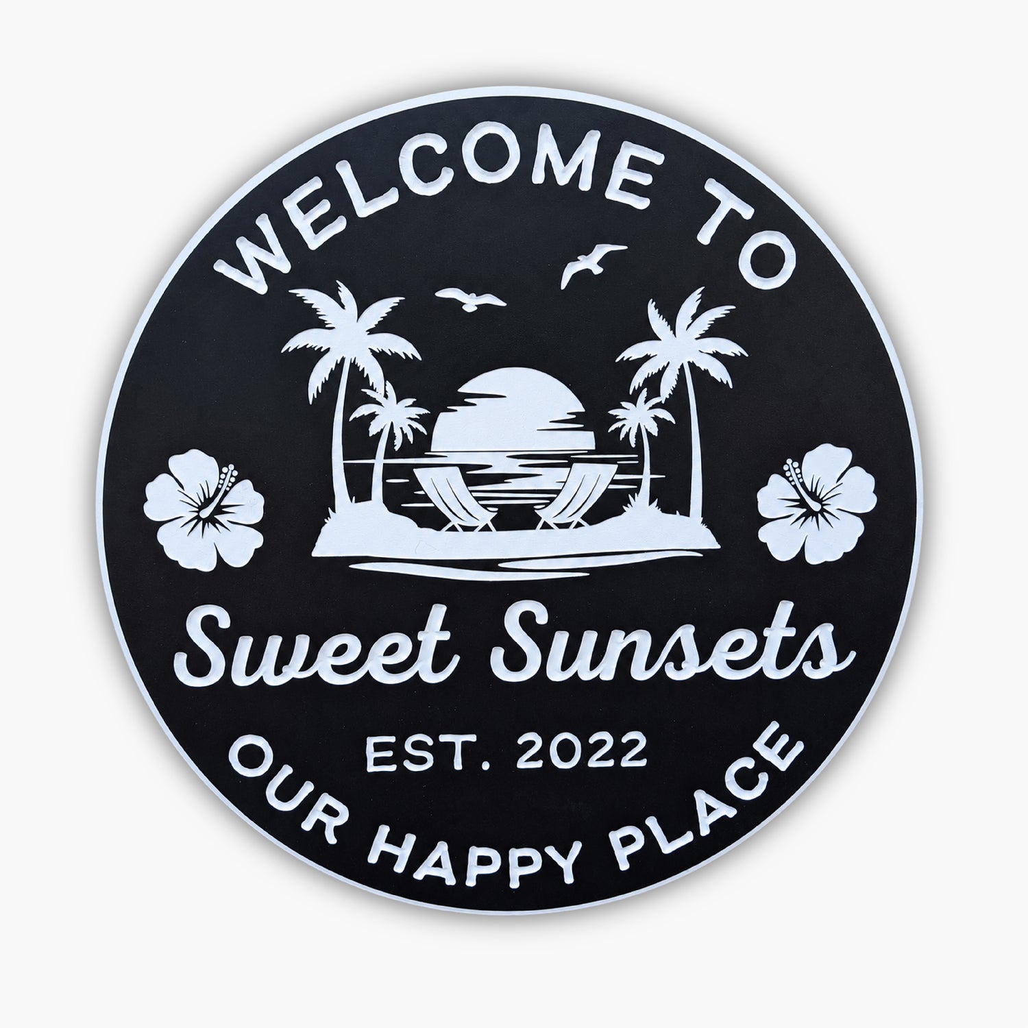 The Personalized Custom Beach House Sign embodies Beach House Signs, featuring a black oval with white text: Welcome to Sweet Sunsets, Est. 2022, Our Happy Place, adorned with a sunset, palm trees, hibiscus flowers, seagulls, and hammocks.