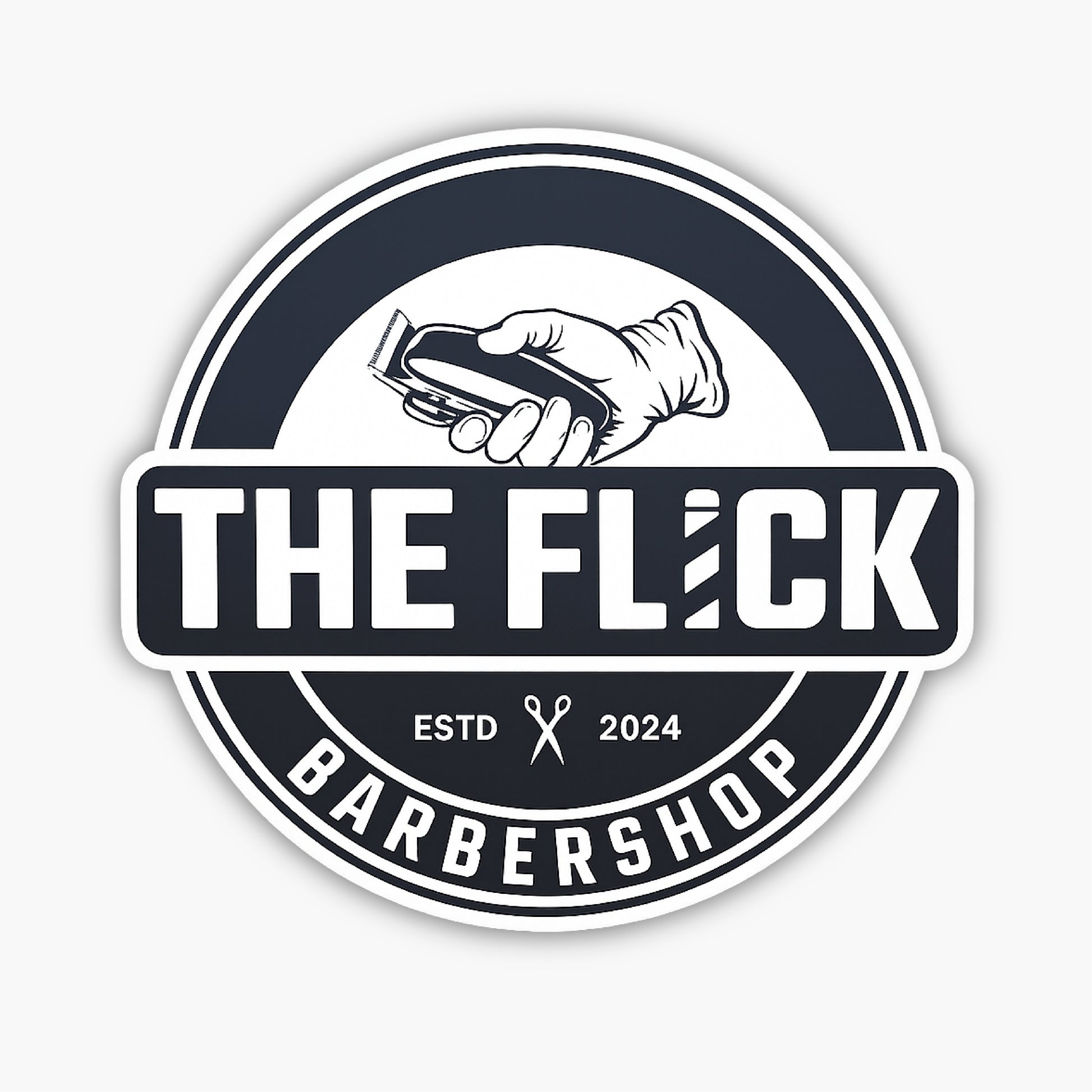 A round black and white barbershop logo with a hand holding hair clippers above the text THE FLICK. Below are ESTD, scissors icon, 2024, and the word BARBERSHOP around the bottom rim.