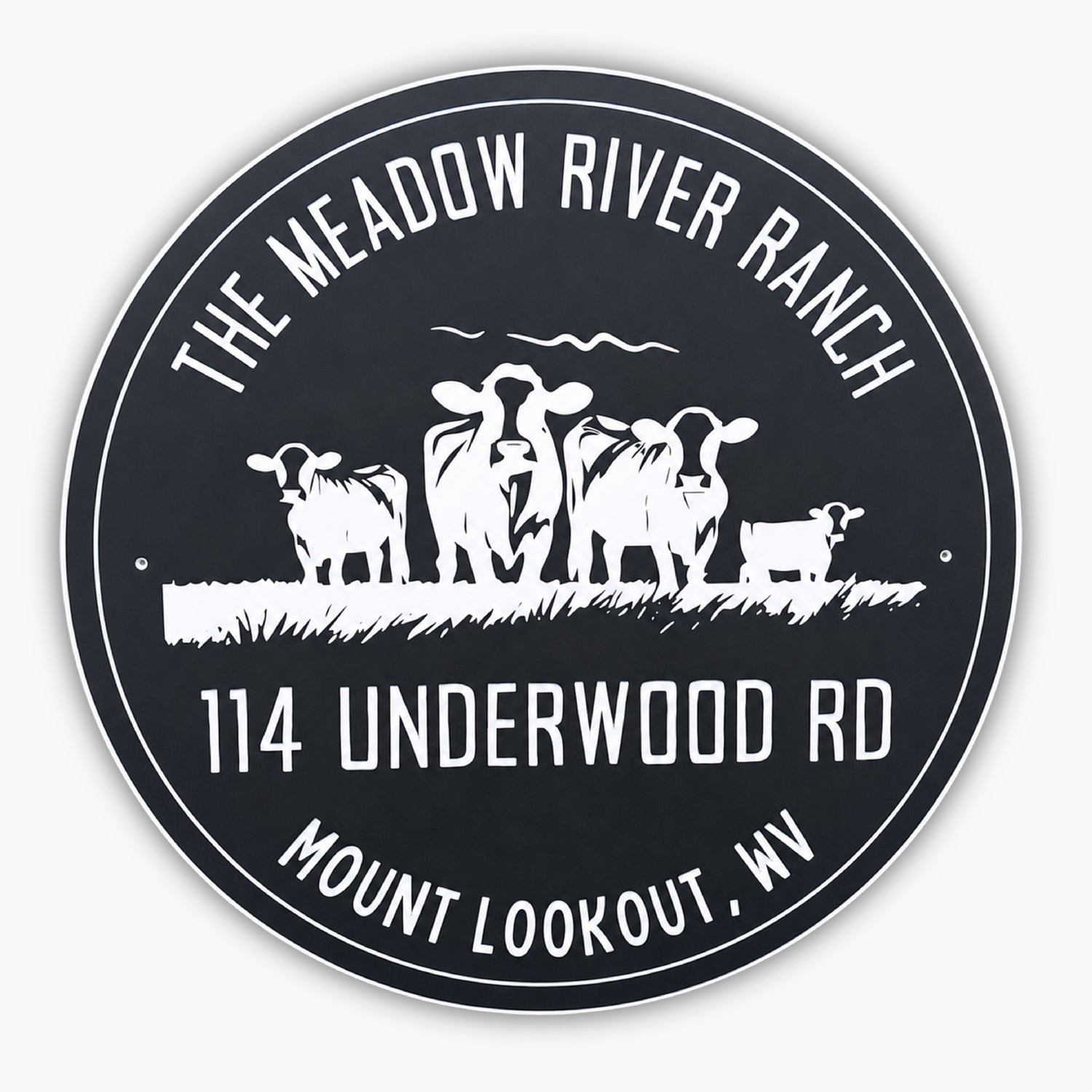 A round sign with The Meadow River Ranch at the top, 114 Underwood Rd, and Mount Lookout, WV at the bottom. In the center, there are silhouettes of three cows and a small calf standing on grass. The sign has a black background with white text and images.
