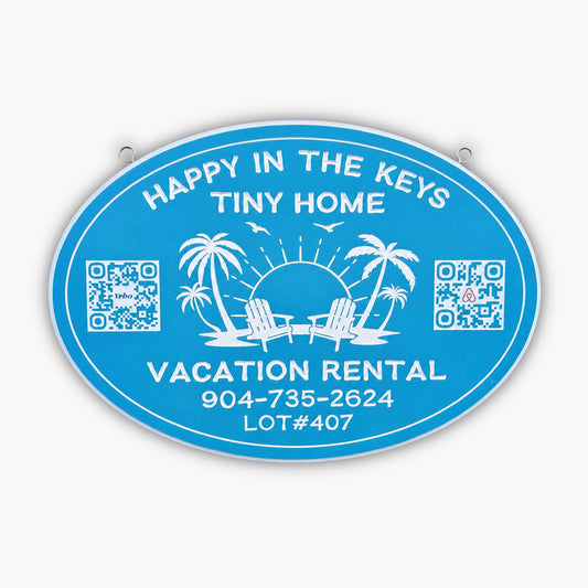 Blue oval sign from Personalized Sign for Vacation Rental, Airbnb, VRBO; features white text: Happy in the Keys Tiny Home, Vacation Rental. Includes phone number, lot number, palm trees, chairs, sun, birds & two QR codes.