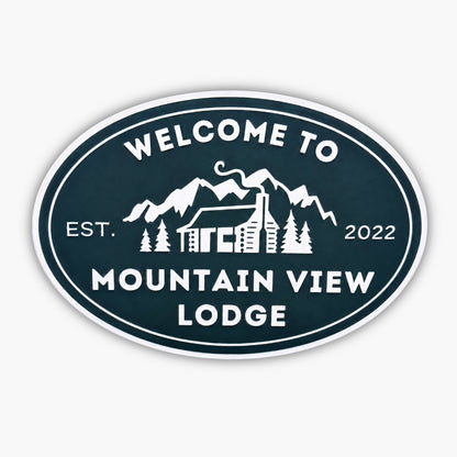 Oval sign reads Welcome to Mountain View Lodge in white, featuring a cabin with a chimney among trees and mountains, echoing the charm of Personalized Oval Custom Beach House Signs Coastal Decor. Established in 2022.