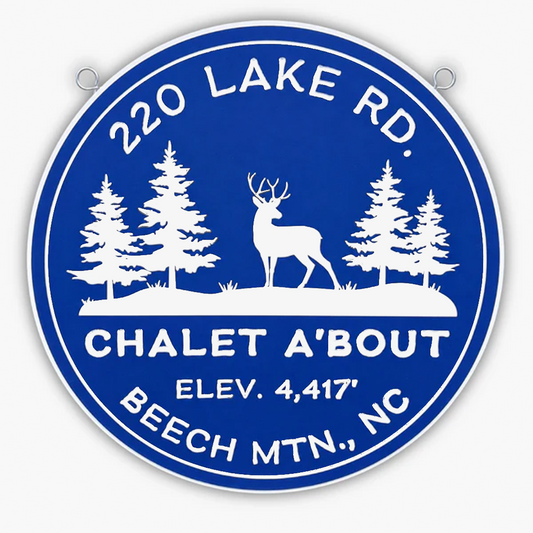 A circular blue pvc sign with white text and silhouettes of a deer and three trees exudes rustic charm. Reading 220 Lake Rd., Chalet A'Bout, Elev. 4,417, Beech Mtn., NC, its perfect for any nature lovers gallery. Two small metal loops at the top make it easy to hang.