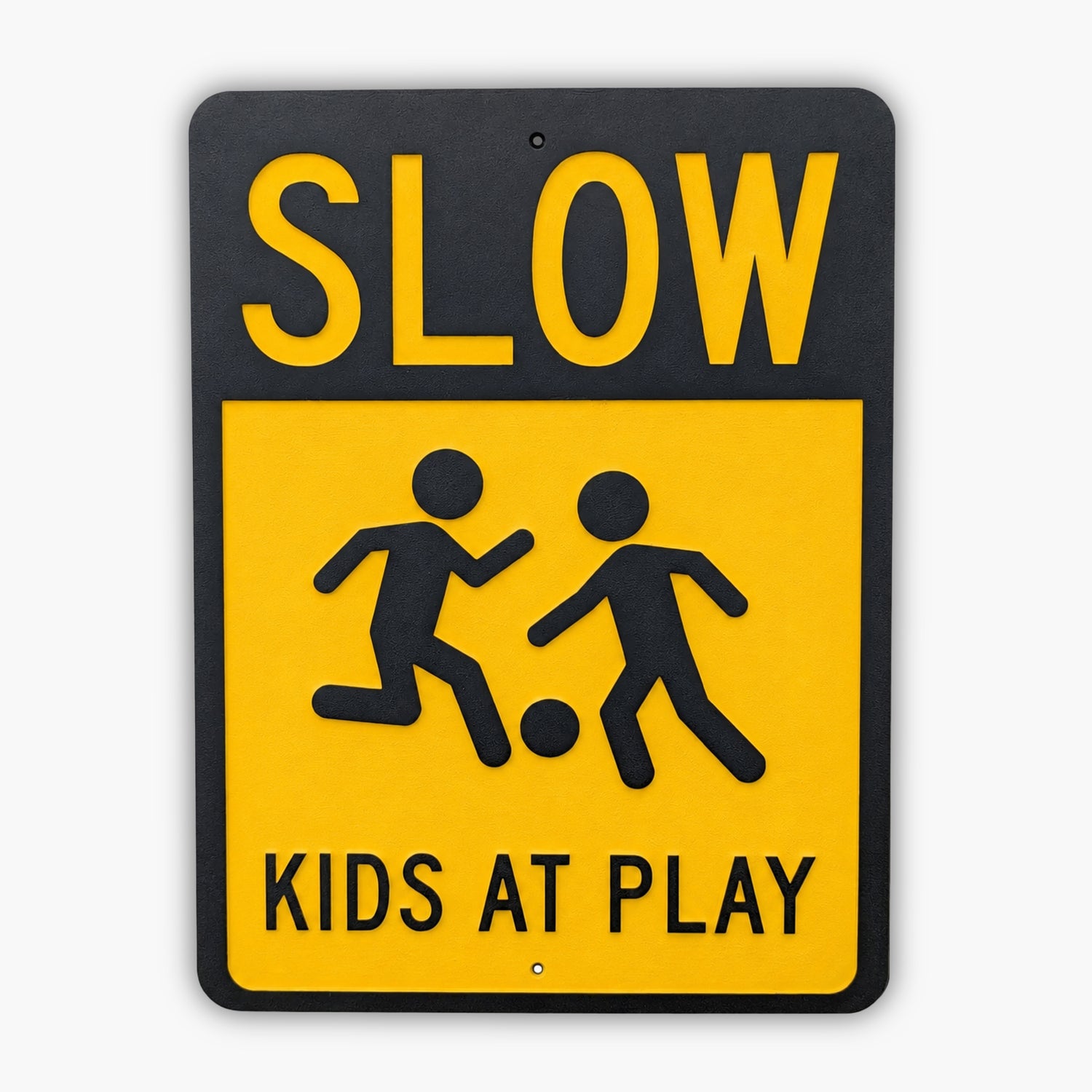 A yellow and black sign reads SLOW KIDS AT PLAY with silhouettes of two children playing with a ball, positioned in front of siding.